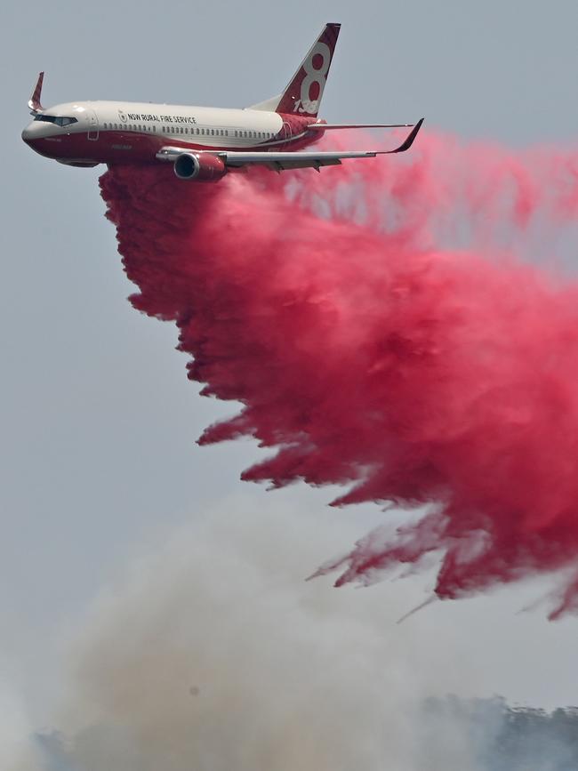 A Rural NSW Fire Service plane drops fire retardent on a bushfire near Taree, on the NSW mid-north coast. Picture: AFP