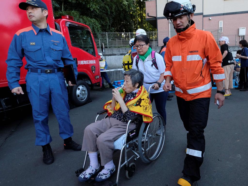 Rescue personnel evacuate an elderly woman from the Kawagoe Kings Garden nursing home in the aftermath of Typhoon Hagibis. Picture: AFP