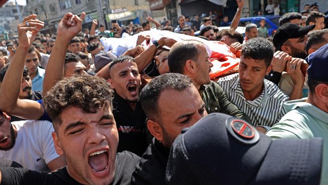 Palestinians carry the body of a victim killed in an Israeli strike, in Khan Yunis in the southern Gaza Strip, on October 7, 2023. (Photo by SAID KHATIB / AFP)