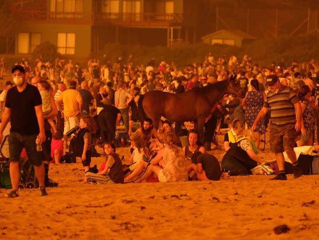 Residents seek refuge on the beach at Malua Bay on the NSW South Coast as the fire approaches. Picture: ALEX COPPEL