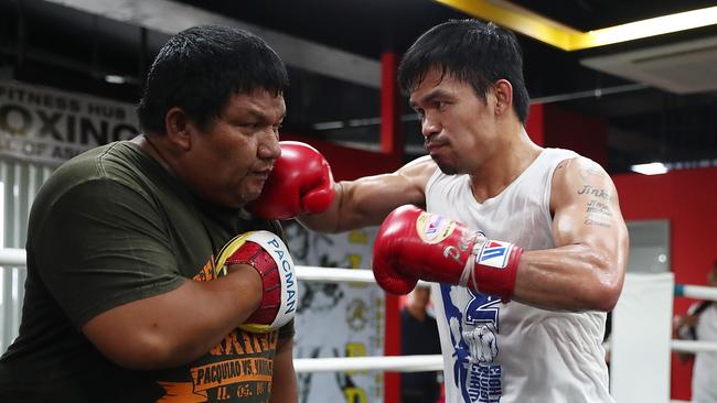 Manny Pacquiao hits the pads with Buboy Fernandez at Elorde boxing gym in Manila. Picture: Getty Images