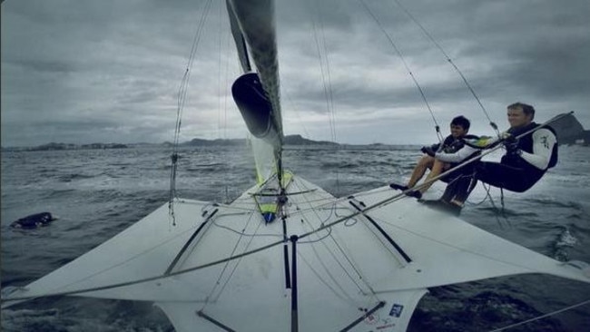 Nathan Outteridge sailing in Rio de Janeiro. To the left of the vessel is a dead dog floating in the water. CREDIT: TWITTER