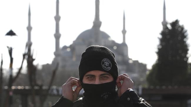 Backdropped by the Sultan Ahmed Mosque, better known as the Blue Mosque in the historic Sultanahmet district of Istanbul, a police officer secures the area after an explosion, Tuesday, Jan. 12, 2016 The explosion killed several people and wounded 15 others Tuesday morning in a historic district of Istanbul popular with tourists. Turkish President Recep Tayyip Erdogan said a Syria-linked suicide bomber is believed to be behind the attack. (AP Photo/Lefteris Pitarakis)