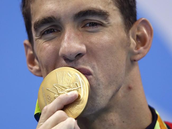 Michael Phelps kisses his 21st gold medal.