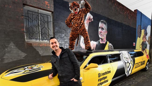 Exotic Limo director Warren Illing with a car painted in Tiger colours at the Dustin Martin mural. Picture: Tony Gough