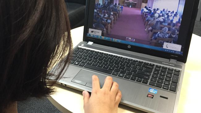 A funeral attendee watching online. Picture: Supplied/OneRoom