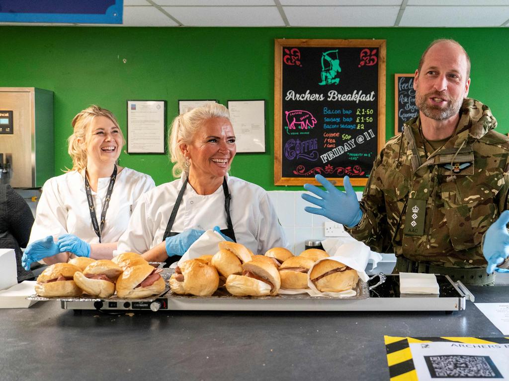 Prince William serves up bacon rolls during a visit to the Army Air Corps in Wattisham, eastern England. Picture: AFP