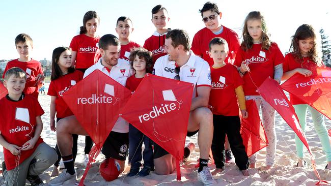 Swans players Harry Cunningham and Tom Papley at Bondi Beach with children including cancer survivor Benjamin Morris, 4 (centre). The Swans have supported Redkite for more than 20 years. Picture: Jonathan Ng