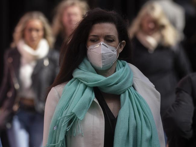 LONDON, ENGLAND - APRIL 01: A woman wears a face mask while walking on Oxford Street on April 01, 2022 in London, England. From today, guidance on voluntary COVID-status certification in domestic settings and the use of the NHS Covid Pass plus requirements for employers to consider COVID-19 in health and safety risk assessments is removed. Free universal symptomatic and asymptomatic testing for the general public is no longer provided with Lateral Flow Tests now available to purchase on the High Street. (Photo by Dan Kitwood/Getty Images)