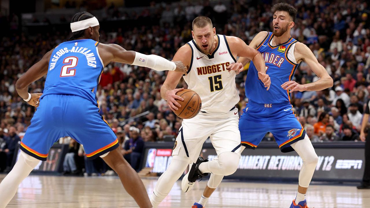 DENVER, COLORADO - OCTOBER 24: Nikola Jokic #15 of the Denver Nuggets drives against Shai Gilgeous-Alexander #2 and Chet Holmgren #7 of the Oklahoma City Thunder in the first quarter at Ball Arena on October 24, 2024 in Denver, Colorado. NOTE TO USER: User expressly acknowledges and agrees that, by downloading and or using this photograph, User is consenting to the terms and conditions of the Getty Images License Agreement. Matthew Stockman/Getty Images/AFP (Photo by MATTHEW STOCKMAN / GETTY IMAGES NORTH AMERICA / Getty Images via AFP)