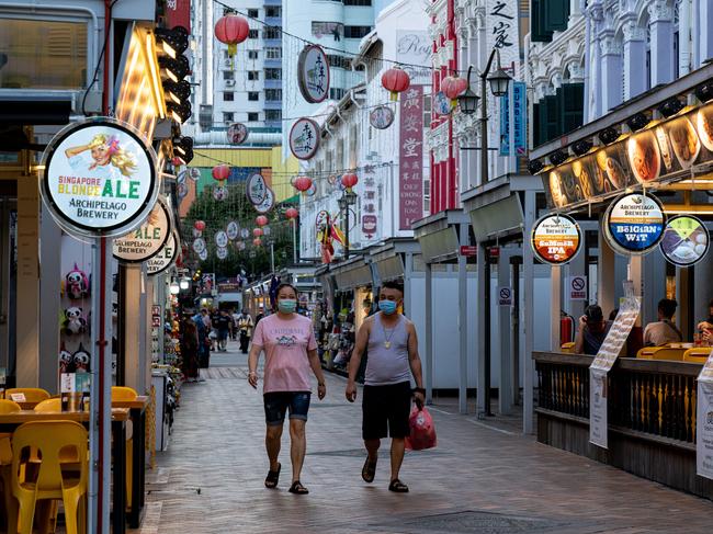 People wearing masks walk on the street in Chinatown in Singapore. Picture: Getty