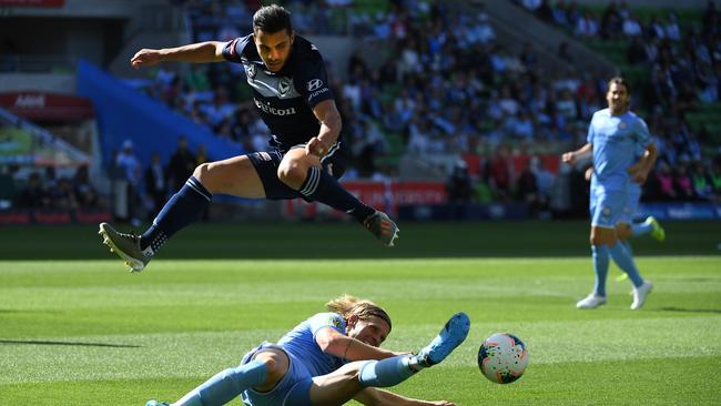Melbourne Victory forward Andrew Nabbout hurdles Melbourne City’s Harrison Delbridge during Victory’s 2-1 win at AAMI Park just before Christmas. Picture: AAP