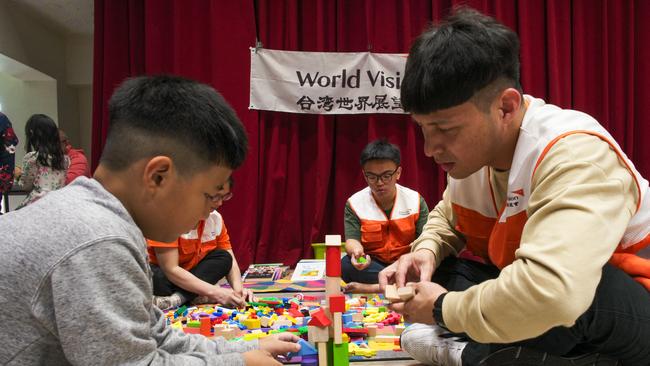 A young evacuee plays with a volunteer at a shelter in Hualien. Picture: AFP