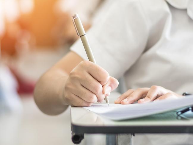 Exam with school student having a educational test, thinking hard, writing answer in classroom for university education admission and world literacy day concept