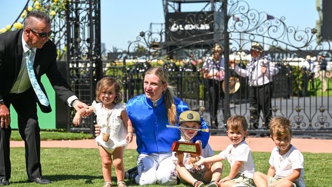 Jamie Kah poses with Dean Holland's father, Darren, and his four children.