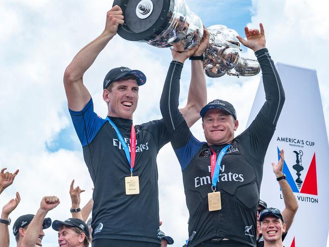 Emirates Team New Zealand helmsman Peter Burling and skipper Glenn Ashby hold aloft the America's Cup.