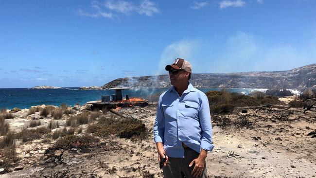 James Baillie standing in front of a burning table a couple of days after the fire ripped through.