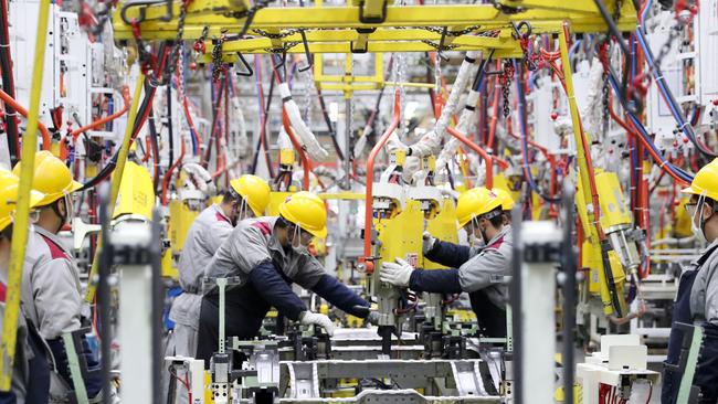 Employees working on a car assembly line at a Beijing Automotive factory in Qingdao, in China's eastern Shandong province.