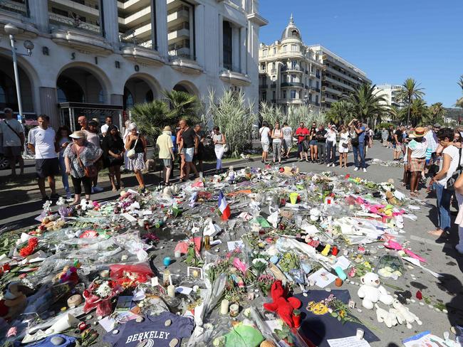 People gather near flowers placed at a makeshift memorial near the Promenade des Anglais in Nice. Picture: AFP