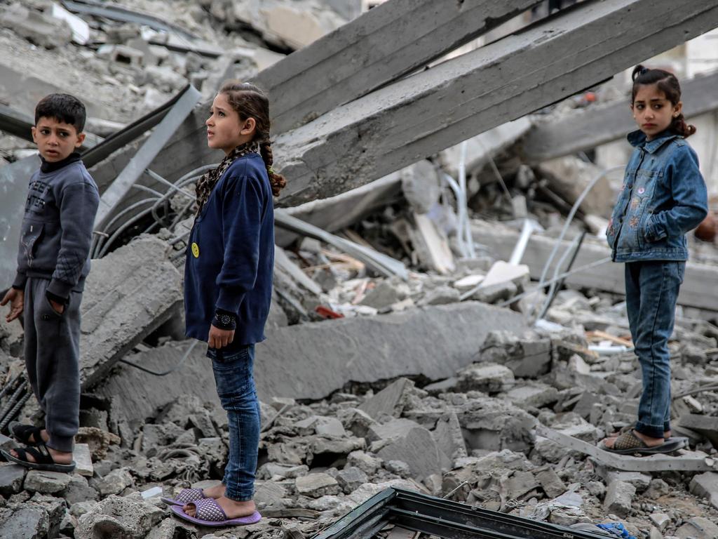 Palestinian children look at the rubble of a building, after it was destroyed in an Israeli strike the night before, in Gaza City. Picture: AFP