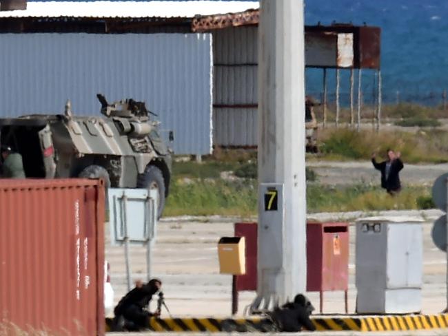 A man exits the plane while snipers point their weapons at him. Picture: AFP/GEORGE MICHAEL