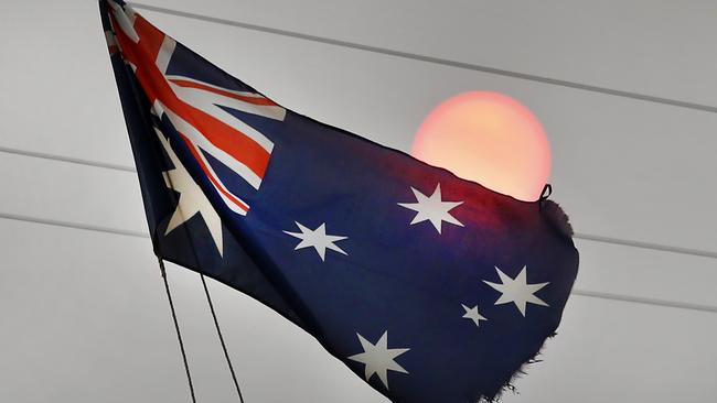 A frayed Australian flag still flies against a smoke hazed weak sun at the Mallacoota Golf Club. Picture: David Caird