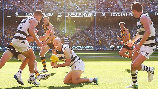 Gary Ablett dishes off a handball to Joel Selwood, with Patrick Dangerfield nearby. Picture: Getty Images