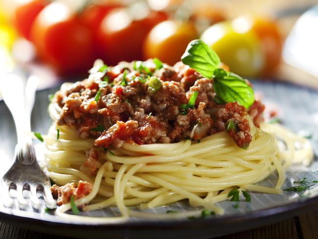 fresh pasta bolognese with basil, shallow dof, focus in front