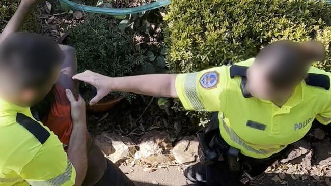 Indigenous boy Benny is restrained by Northern Territory police officers on Friday.