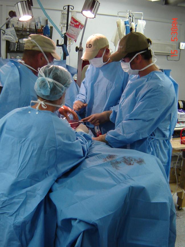 Medic Brad Watts helps operate on a patient at the field hospital at Tarin Kowt