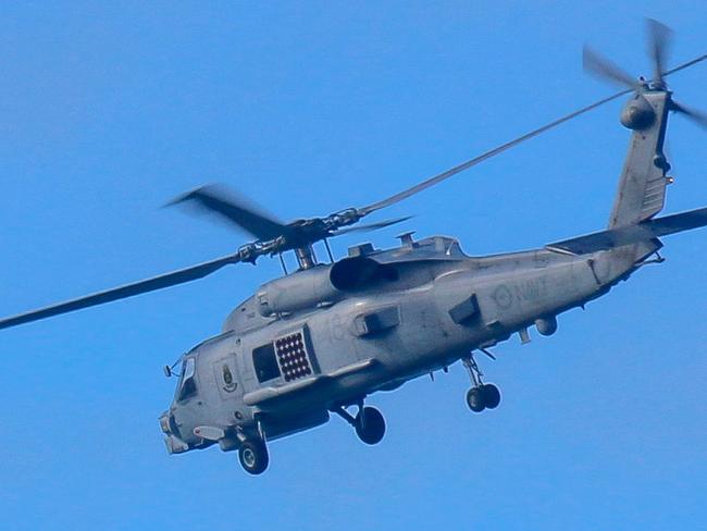 This handout photo taken on July 29, 2023 and received on July 30 from the Australian Defence shows a Royal Australian Navy helicopter conduct search and rescue operations in the vicinity of Lindeman Island, Queensland. Australia's military will ground its fleet of MRH-90 Taipan helicopters after a crash during multinational military exercises that left four crew members missing, the army chief said on July 30. (Photo by AUSTRALIAN DEFENCE / AFP) / ----EDITORS NOTE ----RESTRICTED TO EDITORIAL USE MANDATORY CREDIT " AFP PHOTO / AUSTRALIAN DEFENCE" NO MARKETING NO ADVERTISING CAMPAIGNS - DISTRIBUTED AS A SERVICE TO CLIENTS