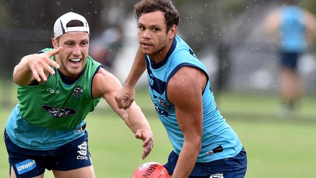 Geelong Cats training at Deakin Uni. Steven Motlop gets it away in front of Sam Menegola. Picture Jay Town.