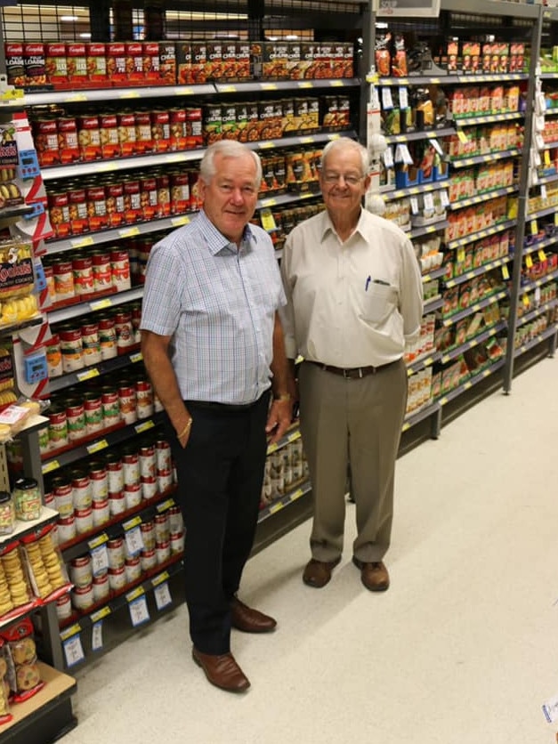Roger Priestley and John Boundy pose again in front of the shelves on the last day.
