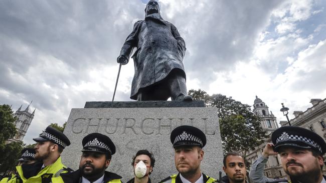 Police officers stand in front of the Winston Churchill statue during a rally last week in Parliament Square, London. Picture: AP