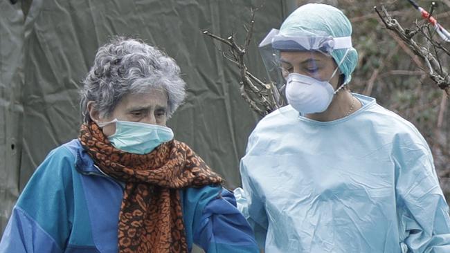 An elderly patient is helped by a doctor at one of the emergency structures that has been set up in northern Italy. Picture: AP/Luca Bruno