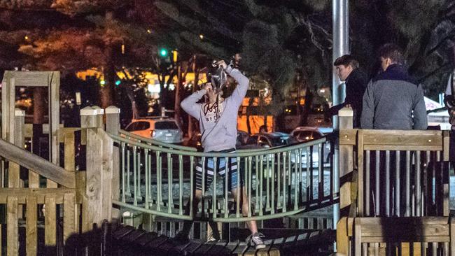 A man skolls cask wine on a playground. Picture: Jason Edwards