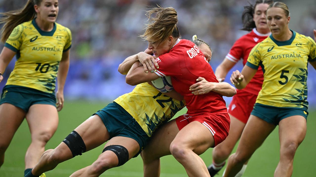 Canada's Caroline Crossley is tackled by Australia's Maddison Levi during the women's semi-final rugby sevens match that shattered the gold medal dream for the Australians. Picture: Carl De Souza/AFP