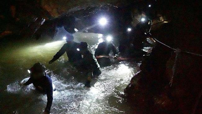 Rescuers make their way through the waterlogged, murky mission deep in a Thai cave. Picture: Thai Navy SEAL via Getty