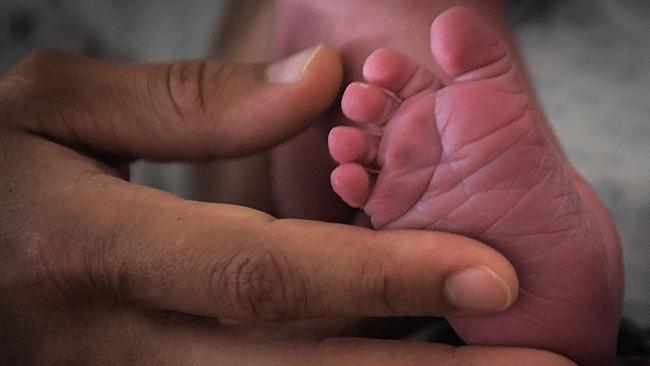 A mother holds the feet of her newborn baby in hospital in Nantes, western France, on July 8, 2018. During a press-conference on January 16, 2024 French President Emmanuel Macron's laid out plans to revive France's sluggish birth rate, promising better parental leave and combat infertility, which he called "the taboo of the century". In 2023, France registered 678,000 births, a drop of 6.6 percent from the previous year, the lowest annual rate since World War II. (Photo by LOIC VENANCE / AFP)