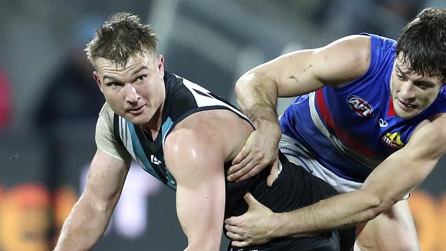 Port Adelaide’s Ollie Wines is tackled by Western Bulldogs’ Josh Dunkley at Adelaide Oval. Picture SARAH REED