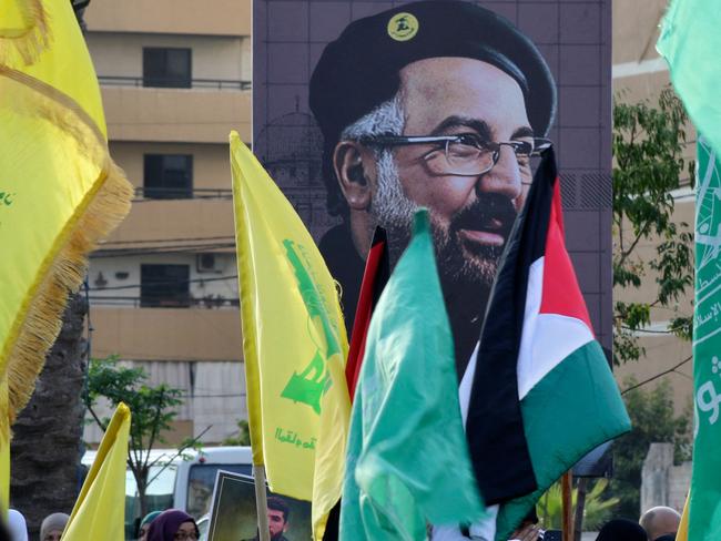 A portrait of slain Hezbollah military commander Fuad Shukr is displayed during a a demonstration denouncing his killing and that of the Palestinian militant Hamas group chief, in the Lebanese coastal city of Sidon, on August 2, 2024. Hamas chief Haniyeh and a bodyguard were killed in a pre-dawn "hit" on their accommodation in Tehran on July 31, Iran's Revolutionary Guards said. Haniyeh's assassination came hours after Israel struck a southern suburb of Beirut, killing Fuad Shukr, the military commander of Lebanese Hamas ally Hezbollah. (Photo by Mahmoud ZAYYAT / AFP)