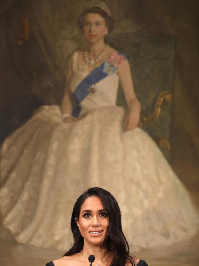 Meghan stands in front of a portrait of Harry’s grandmother, the Queen, she gives her speech. Picture: Getty Images