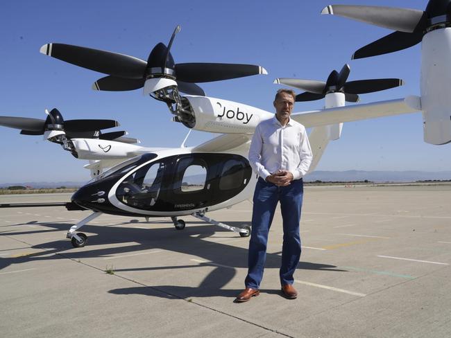 JoeBen Bevirt, CEO of Joby Aviation, stands next to an electric take-off and landing aircraft, also known as an eVTOL, at an airfield in Marina, California. (AP Photo/Terry Chea)