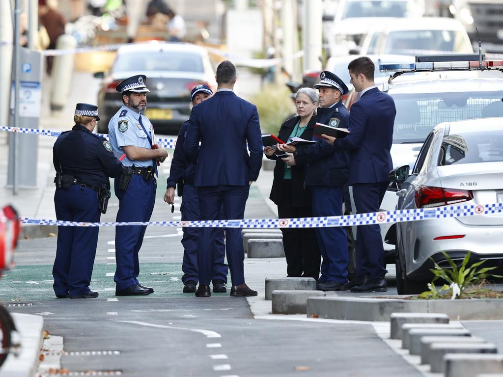 Officers canvass Spring St following the shooting. Picture: Richard Dobson