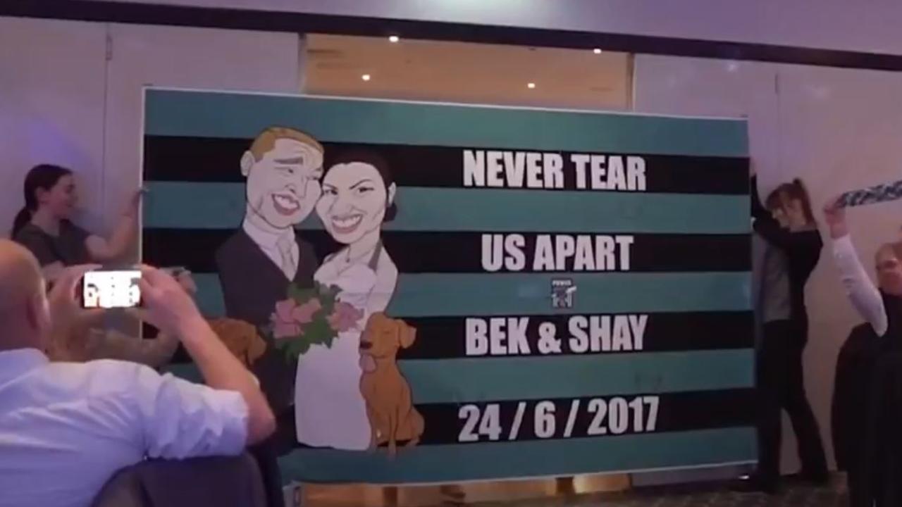 A screengrab from the video on Port Adelaide’s twitter site showing two Power fans running through the banner at their wedding.