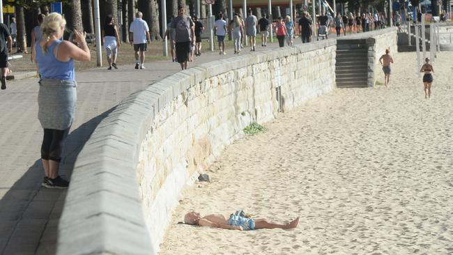 A sunbaker ignores isolation regulations at Manly on April 24, 2020. Picture: Jeremy Piper