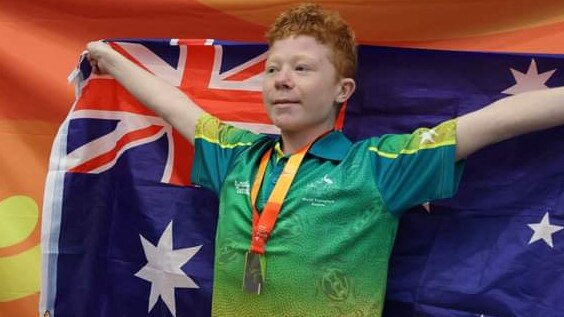 Robbie Yates with the Australian Flag at the World Transplant Games in Perth. Picture: Supplied