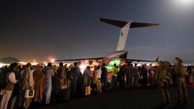 People forming a line to board a Royal Australian Air Force C-17A Globemaster at Hamid Karzai International Airport in Kabul. Picture: AFP PHOTO / AUSTRALIAN DEFENCE FORCE