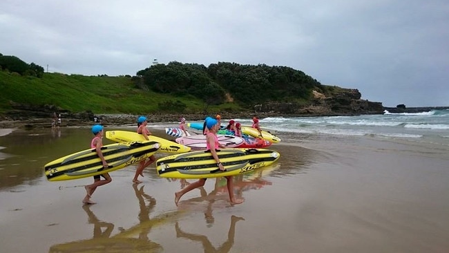 Yamba Surf Lifesaving Club nippers run into the surf during training.