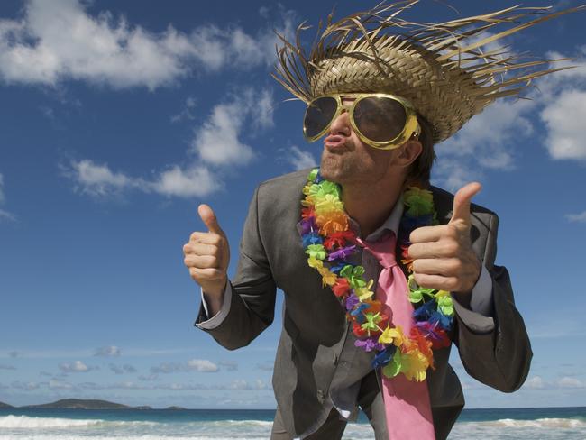 Crazy tourist businessman in a suit, sun hat, and sunglasses giving a funny thumbs-up